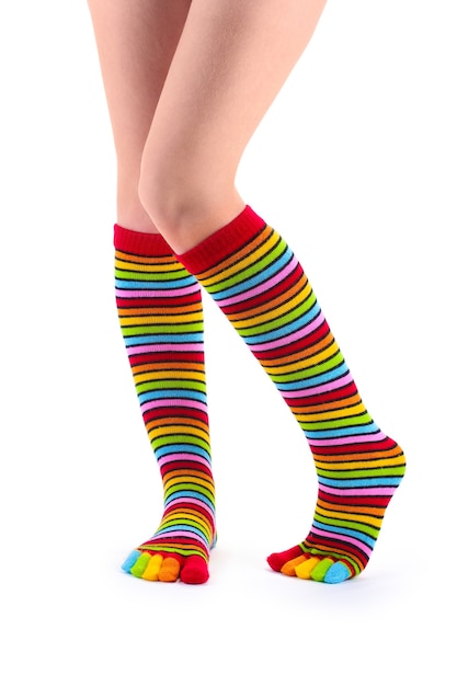 Foto piernas femeninas en calcetines de rayas de colores aislados en blanco
