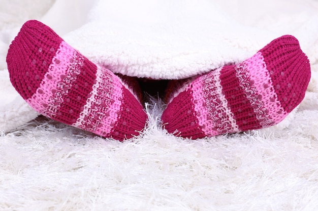 Piernas femeninas en coloridos calcetines en el espacio de la alfombra blanca