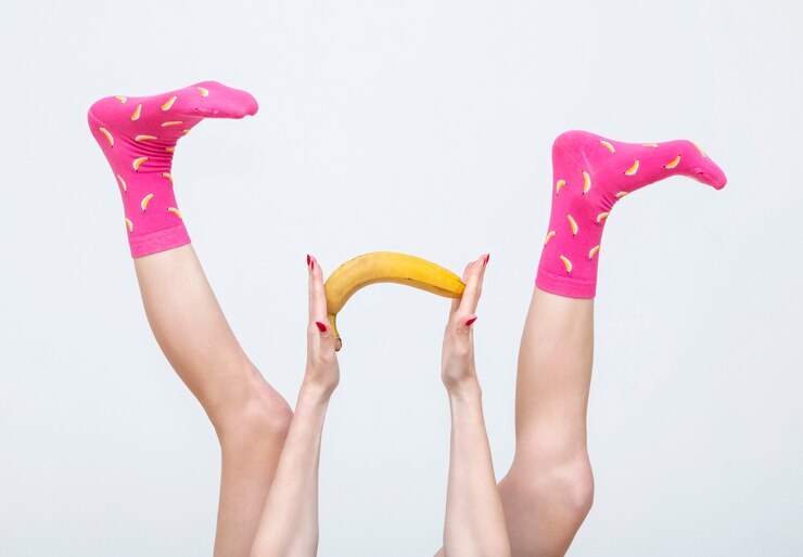 Foto piernas femeninas en coloridos calcetines con limones aislado sobre fondo blanco.