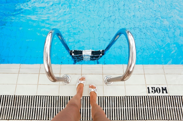 Piernas femeninas en el fondo de la piscina