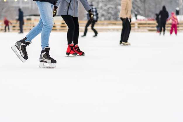 piernas femeninas y masculinas en patines en la pista de hielo