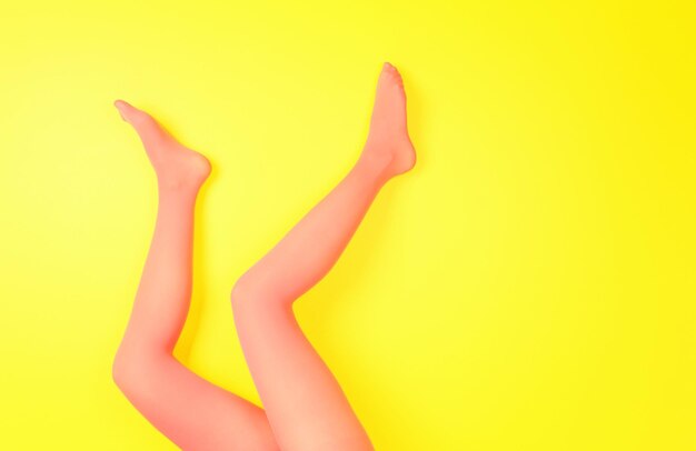 Foto piernas femeninas en medias rosas sobre fondo de color