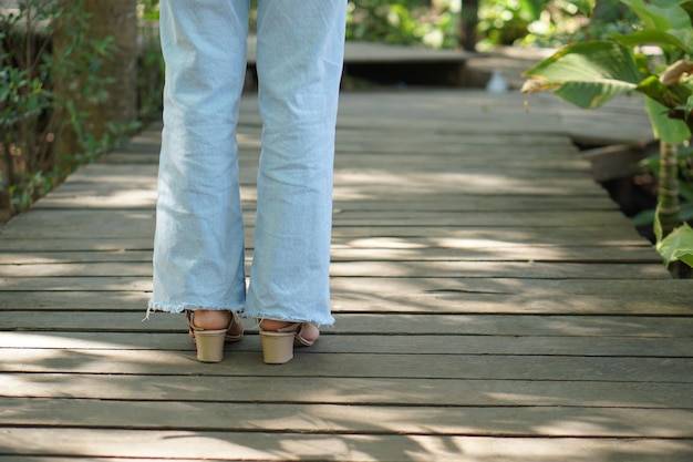 Piernas femeninas que caminan en el paseo marítimo de madera