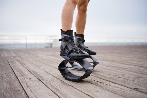 Piernas femeninas con zapatos de salto en la playa