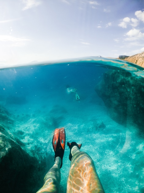 Piernas de hombre en aletas bajo el agua copia espacio vacaciones de verano