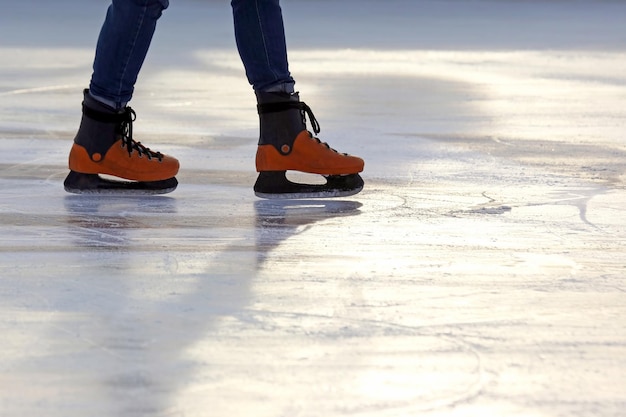 Las piernas de un hombre patinando en la pista de hielo.