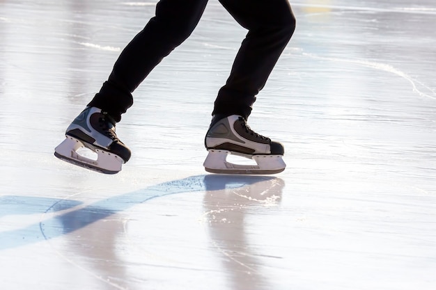 Foto las piernas de un hombre patinando en la pista de hielo.