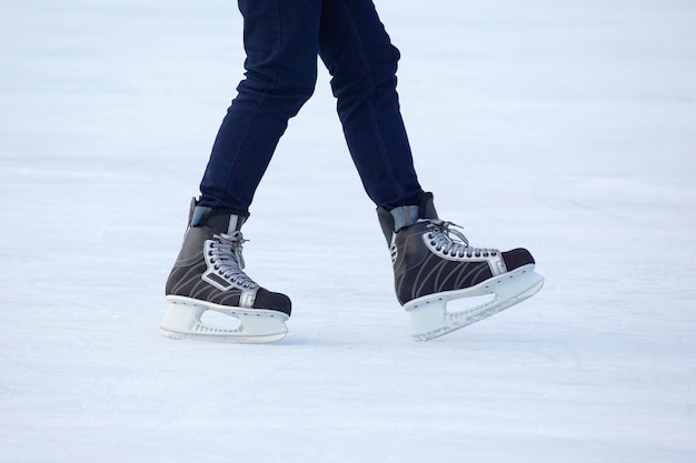 Las piernas de un hombre patinando en la pista de hielo.