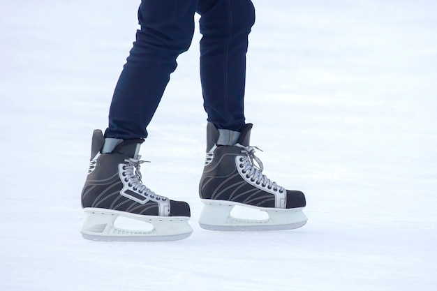 Las piernas de un hombre patinando en la pista de hielo.