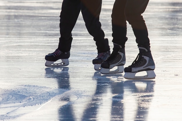 Las piernas de un hombre patinando en la pista de hielo.