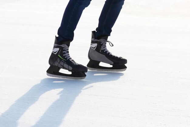 Las piernas de un hombre patinando en la pista de hielo.