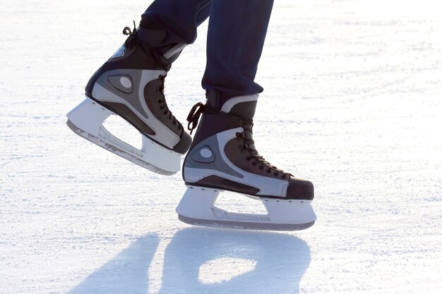 Piernas de un hombre patinando sobre una pista de hielo.