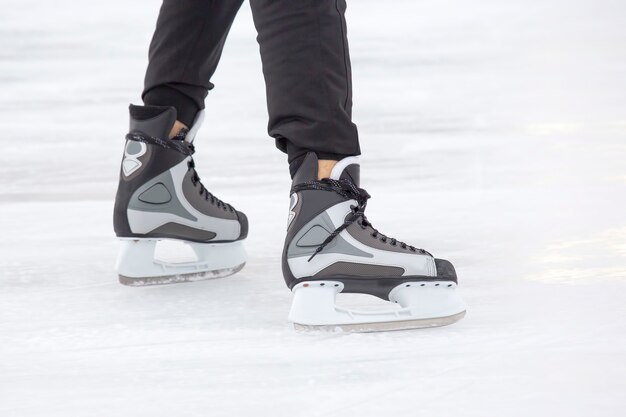 Piernas de un hombre patinando sobre una pista de hielo.