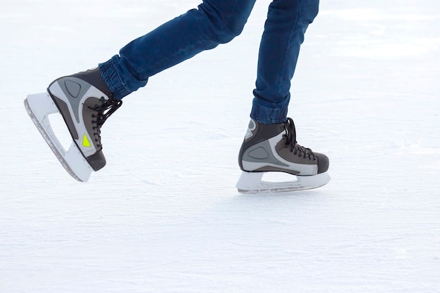 Piernas de un hombre patinando sobre una pista de hielo