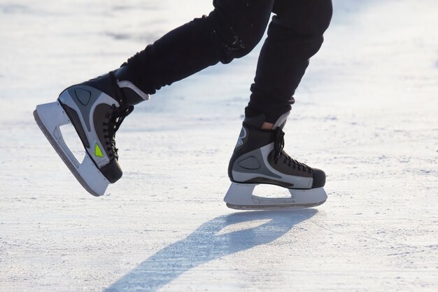 Piernas de un hombre patinando sobre una pista de hielo