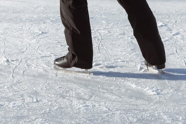 Las piernas de los hombres en patines negros se cierran en la pista en el momento del empujón antes de patinar