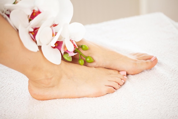 Piernas largas y delgadas de mujer con flores rosas.