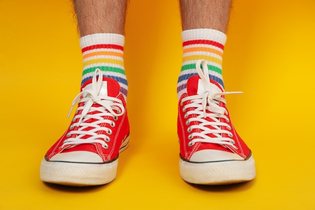 Piernas masculinas en zapatillas rojas y calcetines LGBT