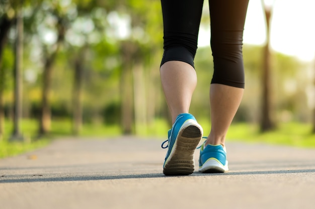 piernas de mujer fitness caminando en el parque, funcionamiento femenino y ejercicio. Deporte y bienestar