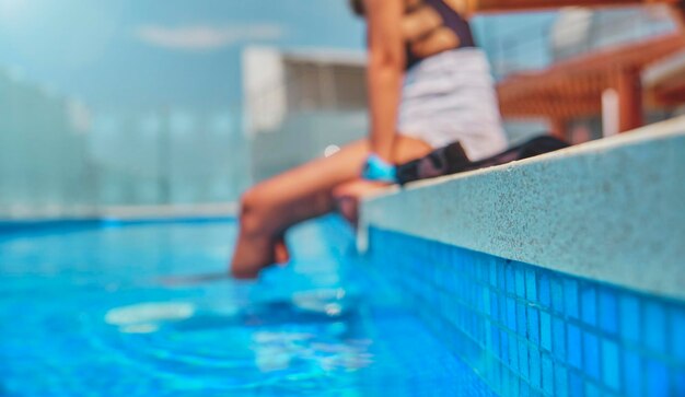 Piernas de mujer irreconocibles durante un día de verano en una piscina