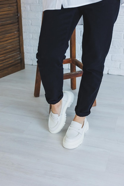 Piernas de una mujer joven y hermosa con pantalones negros y modernos y elegantes mocasines de cuero blanco nueva colección de zapatos de mujer primaveraverano 2022 | Foto Premium Piernas de una mujer joven y hermosa con pantalones negros y modernos y elegantes mocasines de cuero blanco nueva colección de zapatos de mujer primaveraverano 2022 | Foto Premium