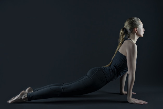 Piernas de mujer joven practicando yoga mat y leggins