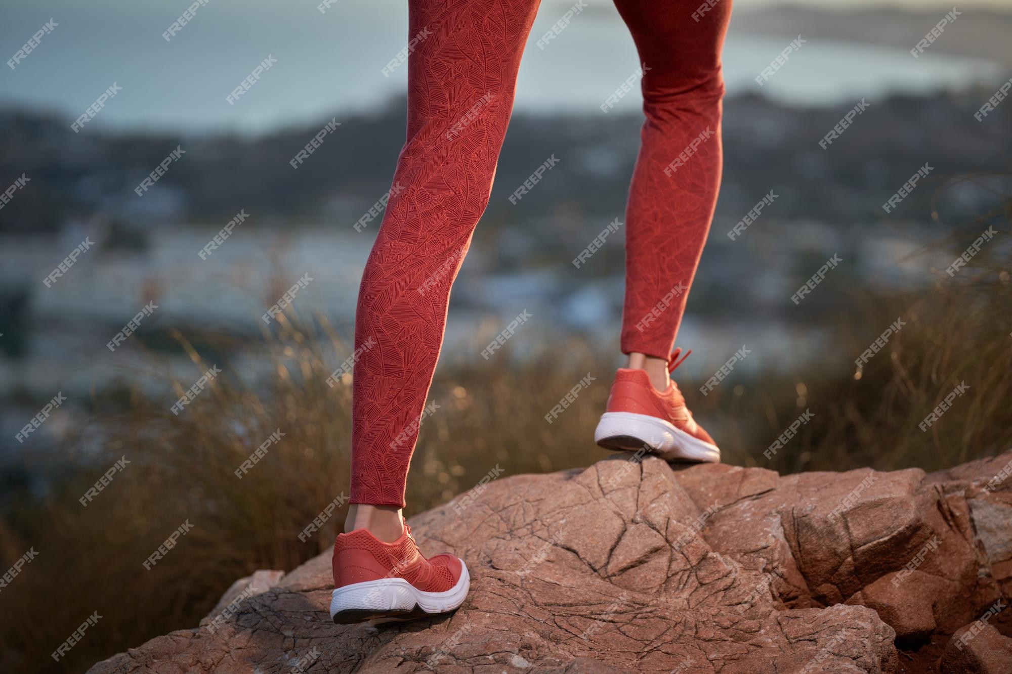 Piernas de mujer en mallas rojas la montaña Foto Premium