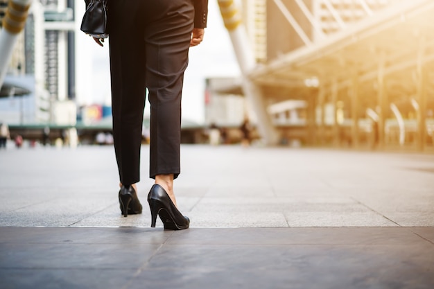 Piernas de mujer de negocios en zapatos de tacones caminando en la ciudad