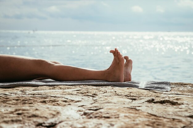 Las piernas de una mujer en la playa se relajan