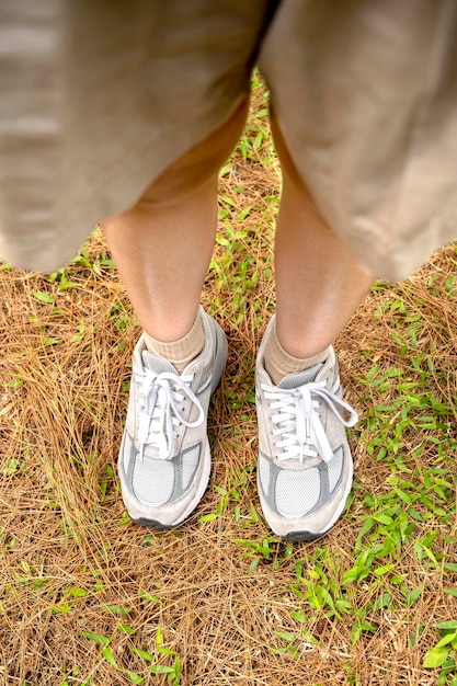 Las piernas de las mujeres con zapatos blancos caminando en el bosque