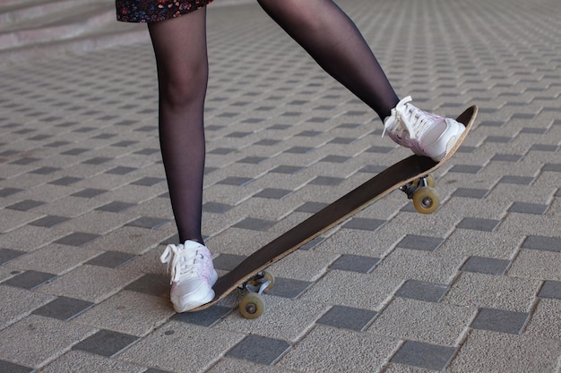 Piernas de niña montando en patineta