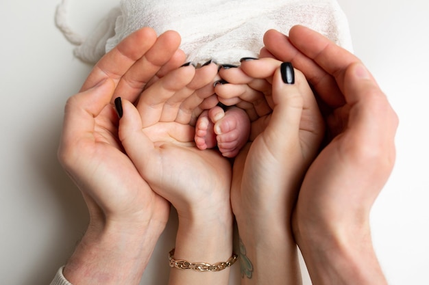 las piernas del niño en los brazos de la madre y el padre las piernas de un bebé recién nacido