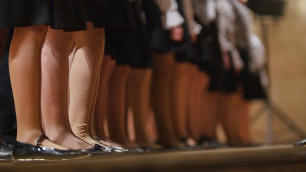 Piernas en pantimedias de niñas ensayo del coro de la canción académica