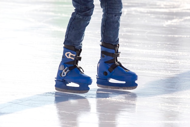 Piernas de un patinador en patinaje sobre hielo en la pista de hielo de la calle. deporte de invierno. aficiones y recreación activa en los deportes.