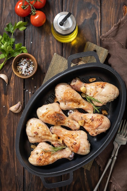 Foto piernas de pollo asadas a la parrilla con romero en una mesa de madera vista superior plana