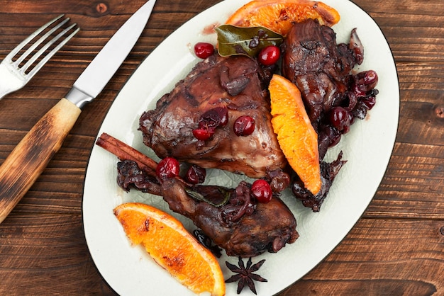 Foto piernas de pollo o baquetas marinadas en vino tinto horneadas con naranja y bayas estilo rústico