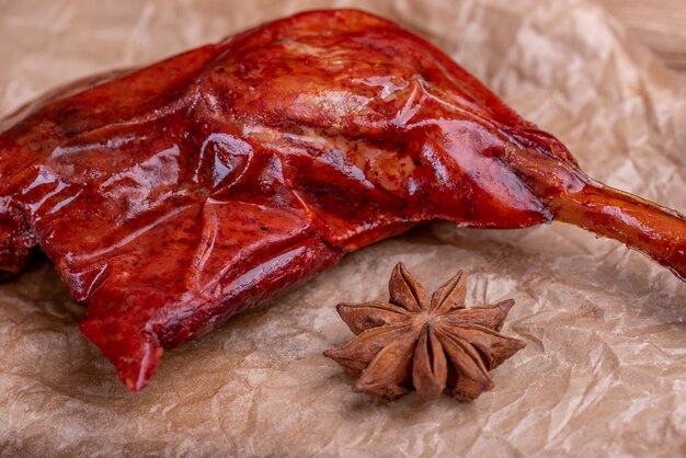 Las piernas de pollo rojo guisado en el recipiente están en un fondo oscuro