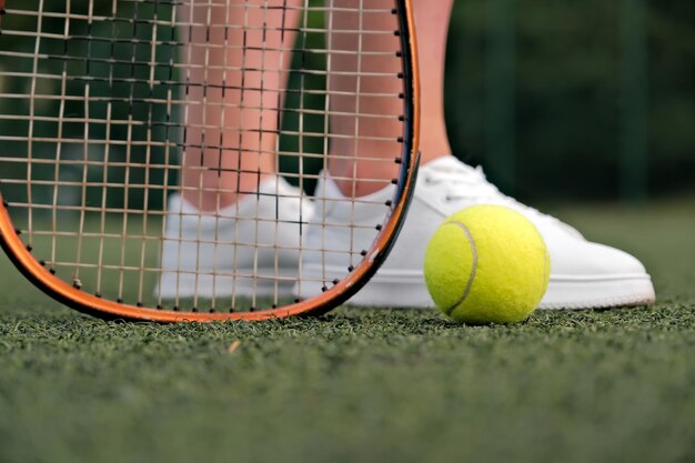 Piernas y raqueta de tenis closeup pelota y raqueta en la cancha de tenis