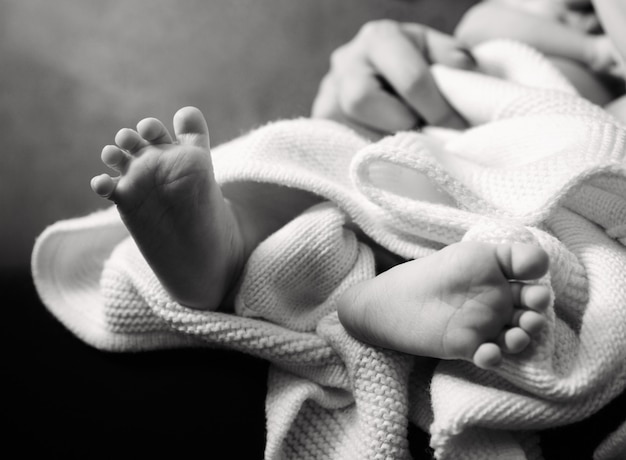 Pies de bebé acostado en blanco y negro