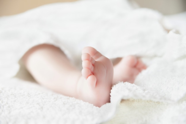 Pies de bebé en colcha blanca. Dedos de los pies. Foto horizontal