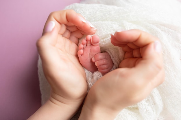 pies de bebé en manos de los anillos de boda de los padres de la madre en los dedos de los pies de un recién nacido