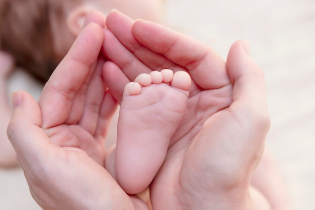 Foto pies de bebé en manos de la madre de la madre