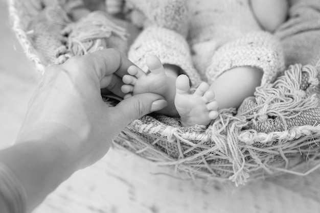 Pies de bebé en manos de la madre Pies de bebé recién nacido diminuto en primer plano de manos con forma femenina Mamá y su hijo Concepto de familia feliz Hermosa imagen conceptual de maternidad