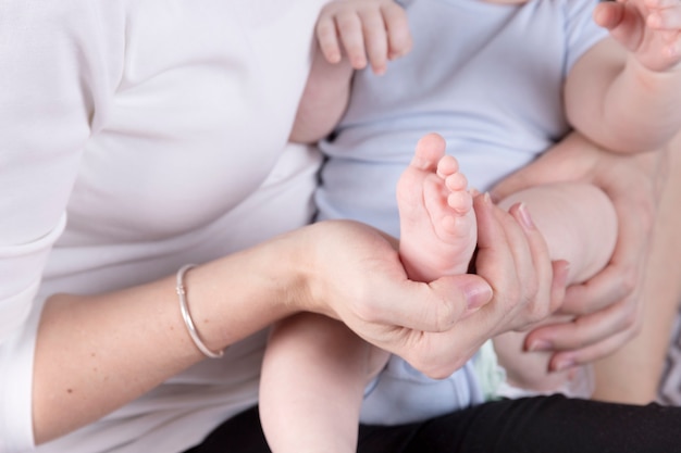 Pies de bebé en manos de la madre. Pies del pequeño bebé recién nacido en primer plano de manos en forma de mujer.