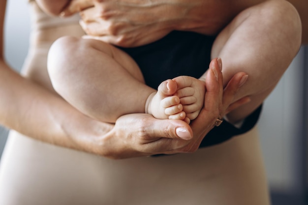 Los pies del bebé en las manos de las madres cierran la foto