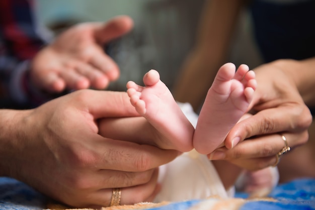 Pies de bebé en manos de los padres. Pies del bebé recién nacido