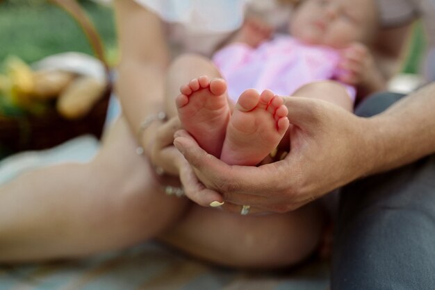 Pies de bebé en manos de sus padres