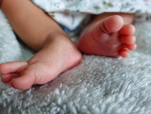 Los pies de un bebé se muestran sobre una manta.