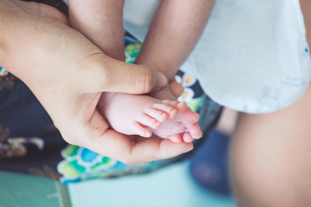 Pies de bebé recién nacido en la mano de la madre con ternura