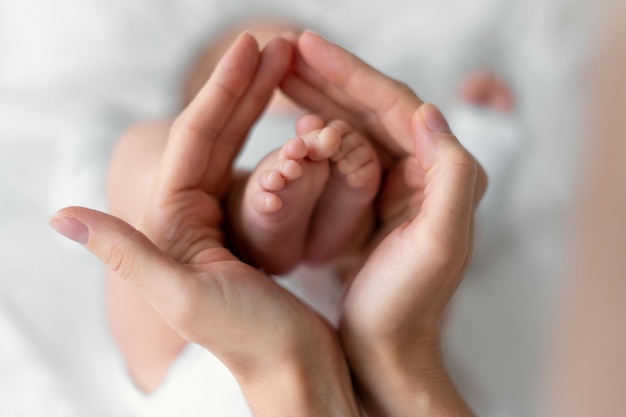 Pies de bebé recién nacido en manos de la madre aislados en blanco. concepto de infancia.